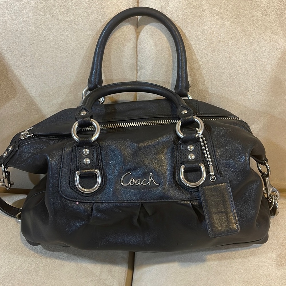 Black coach bag with silver hardware and purple lining